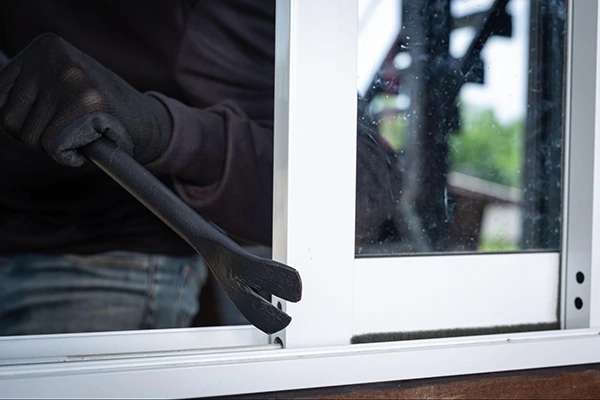A burglar breaking in through a window.