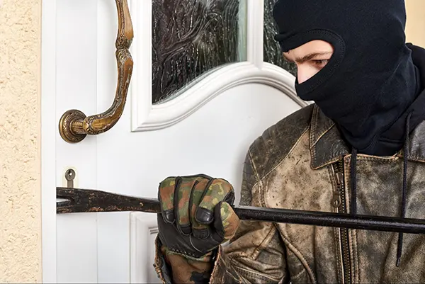 A burglar trying to break into a home.